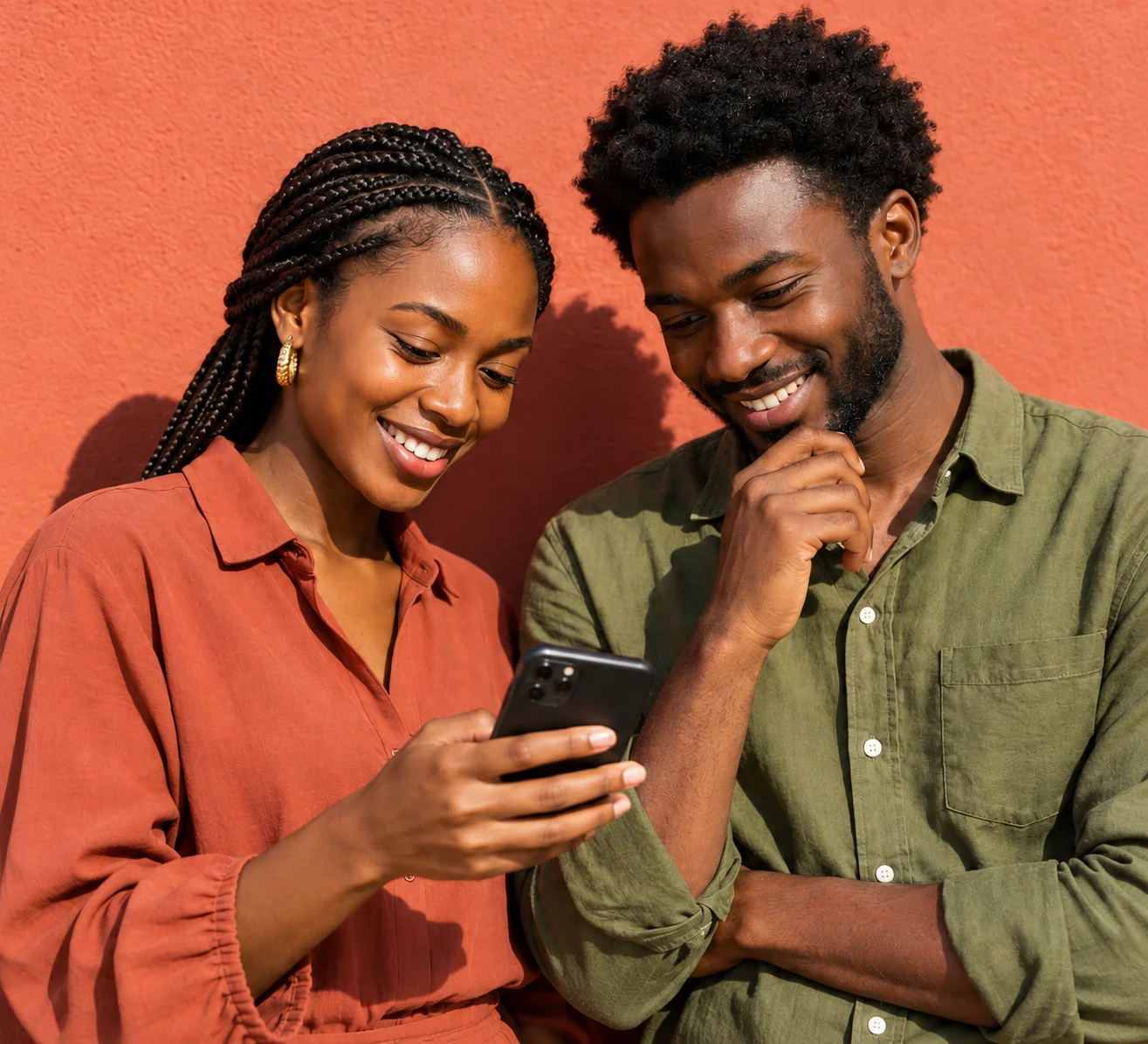 Deux entrepreneurs souriants regardent ensemble une présentation sur un téléphone.